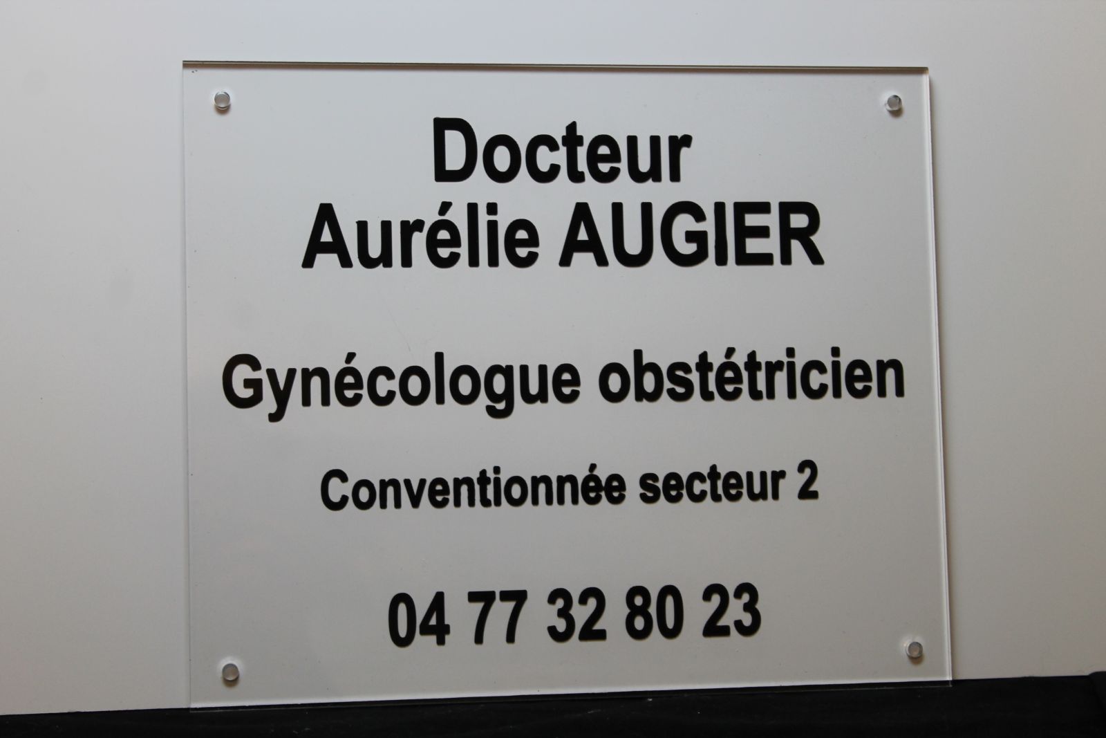 Plaque professionnelle en plexiglas avec gravure et peinture noire pour une gynécologue